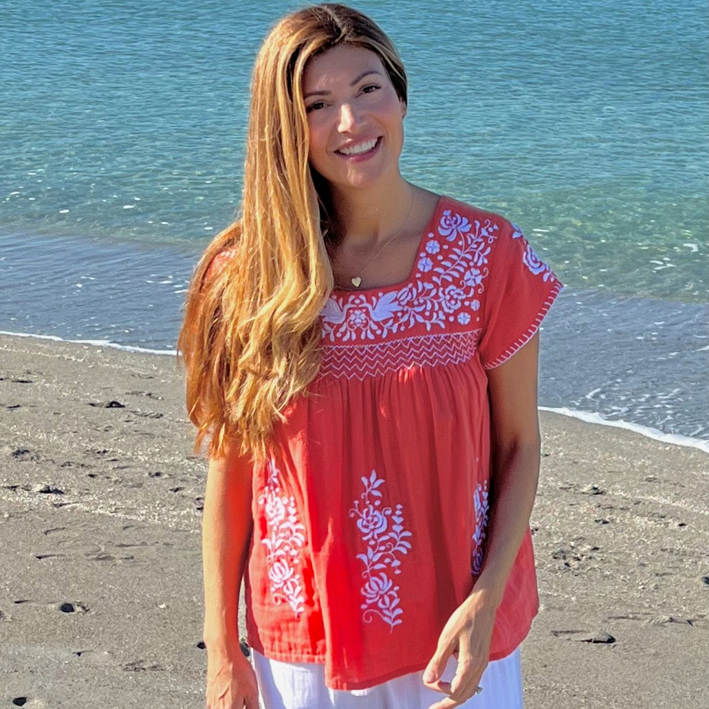 woman in red and white tunic on the beach