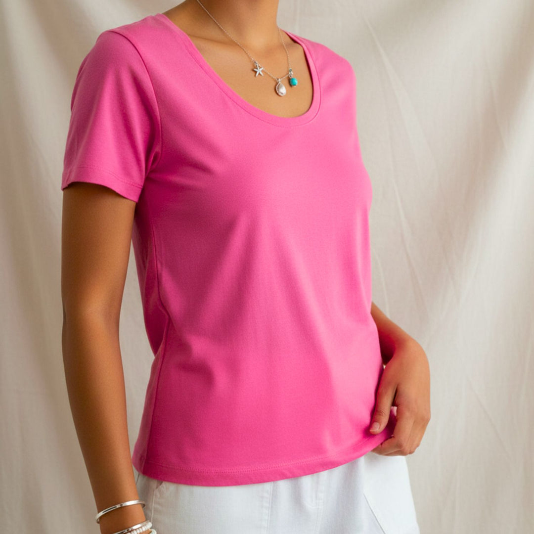 Person wearing a bright pink cotton t-shirt against a plain background