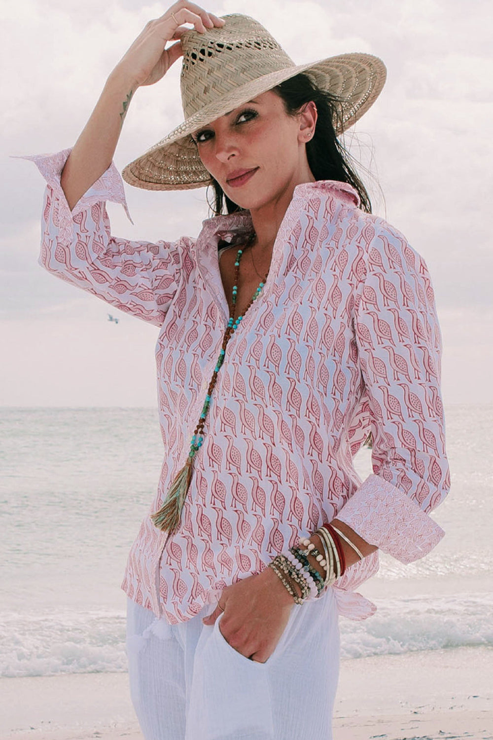 photo of woman with beach back drop in perisimmon shirt 