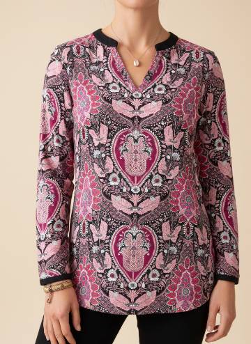Person wearing a pink and black patterned blouse on a beige background