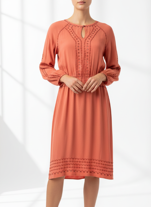 Woman wearing a coral dress on a white background