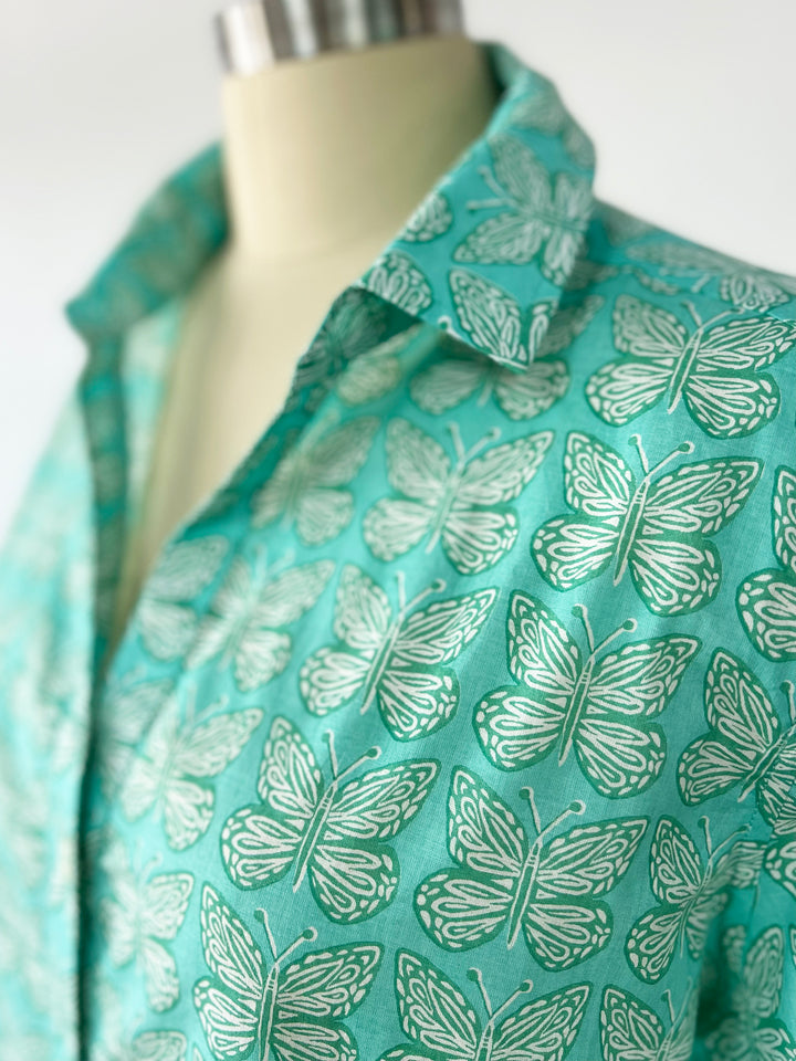 close up of aqua artisan shirt with butterfly print