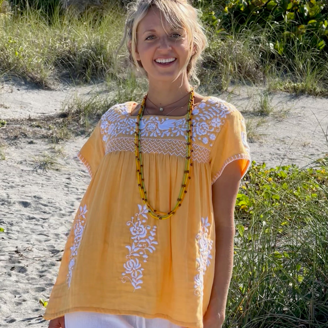 woman in orange tunic on the beach