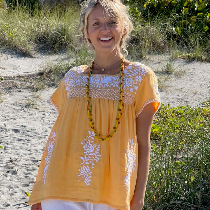 woman in orange tunic on the beach