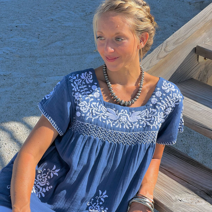 woman in blue and white tunic on the beach
