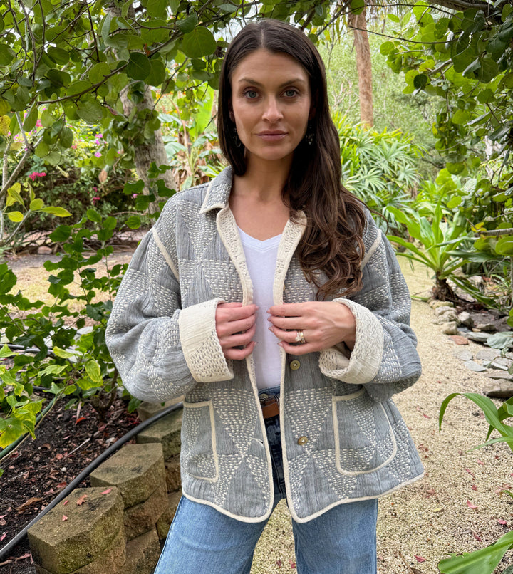 Woman wearing a textured jacket in a garden setting