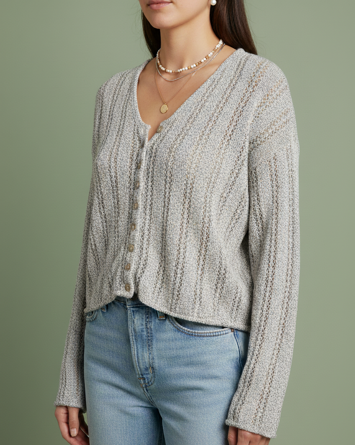 Woman wearing a vintage sigrid olsen textured sweater and light blue jeans against a green background