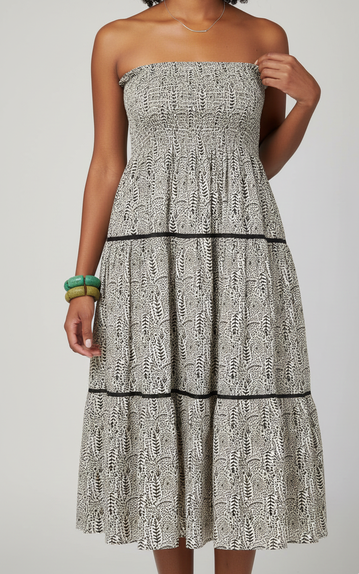 Woman wearing a strapless dress with a pattern on a plain background