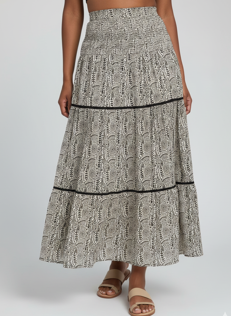 Long patterned skirt worn by a person on a plain background