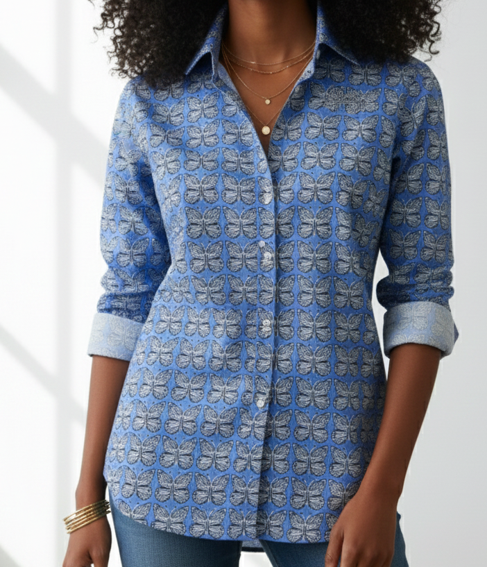 Woman wearing a blue patterned shirt against a white background
