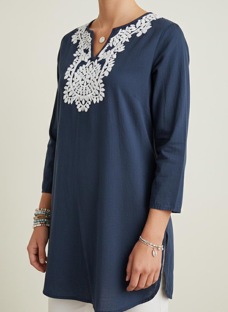 Navy blue tunic with white lace detailing on a plain background
