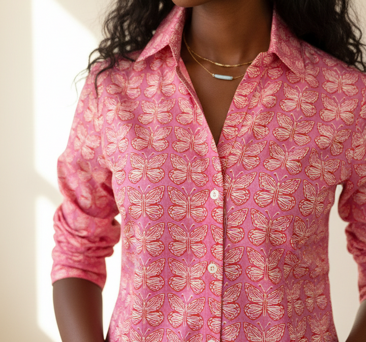 Woman wearing a pink patterned shirt against a neutral background