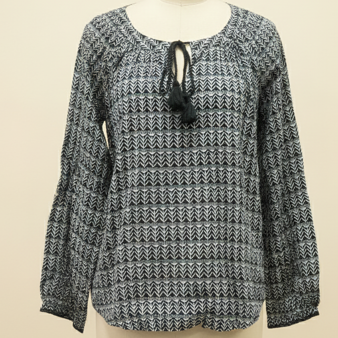 Black and white patterned blouse on a mannequin against a beige background