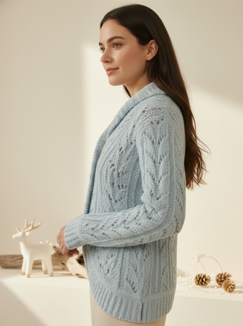 Woman wearing a light blue cable knit cardigan in a warm indoor setting.