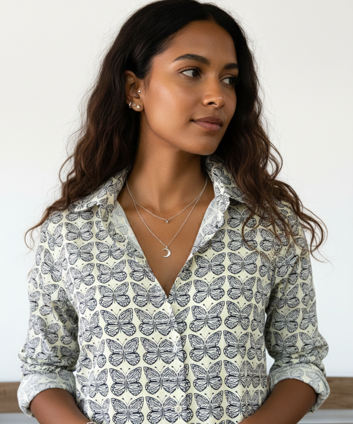 Woman wearing a patterned button up shirt with a neutral background