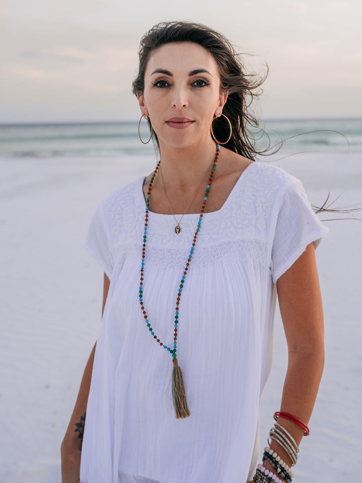 woman in white tunic on the beach