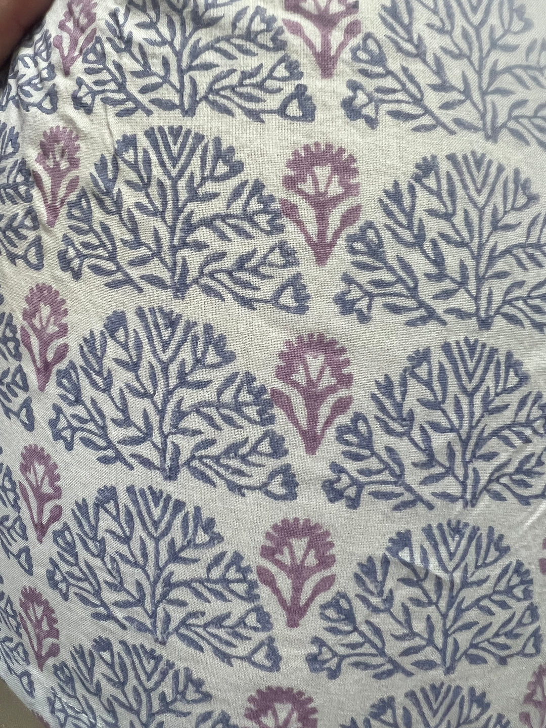 Textile with a floral pattern in purple on a beige background