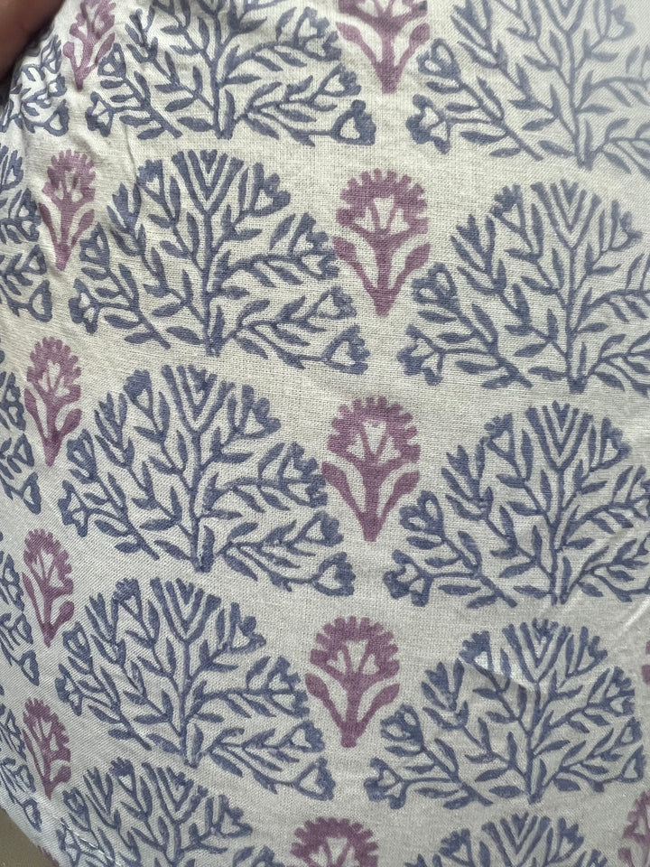Textile with a floral pattern in purple on a beige background