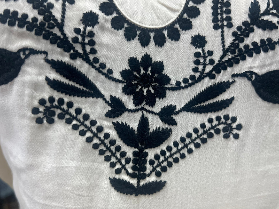 White fabric with dark blue floral embroidery