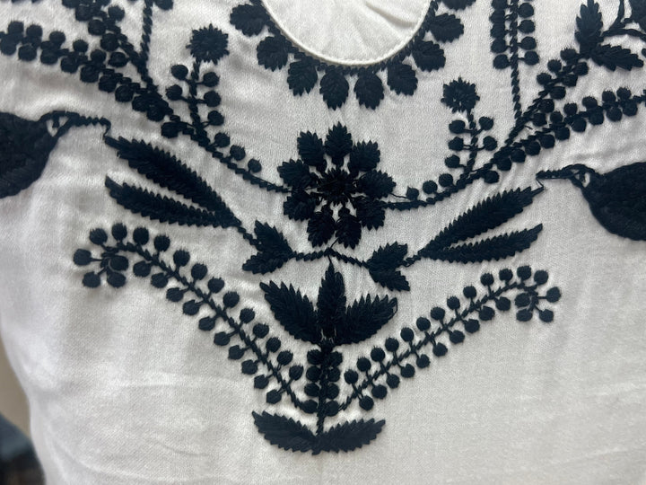 White fabric with dark blue floral embroidery