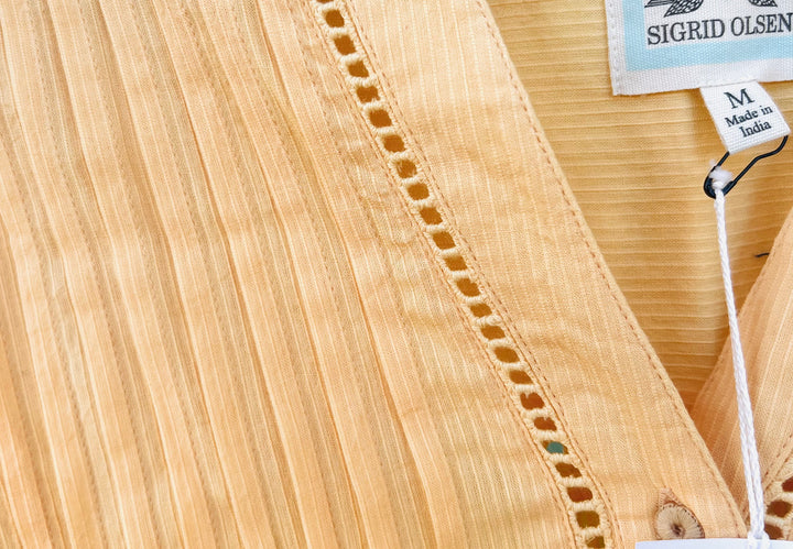 Close-up of a woven fabric with a brand tag on a wooden surface
