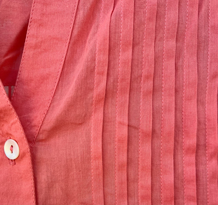 Close-up of a red shirt with a button detail