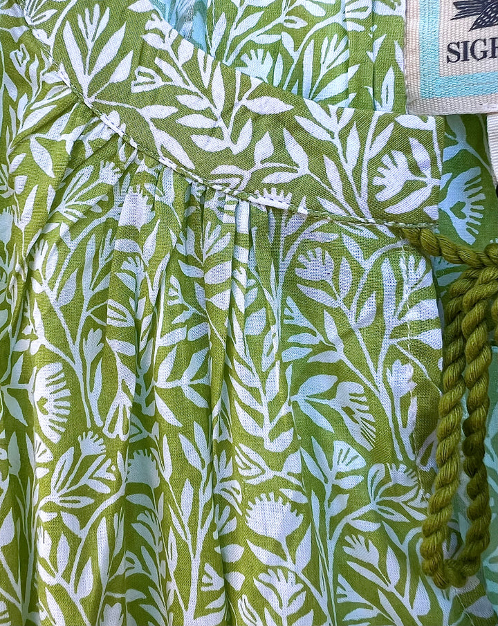 Green and white patterned fabric with a rope and tag visible