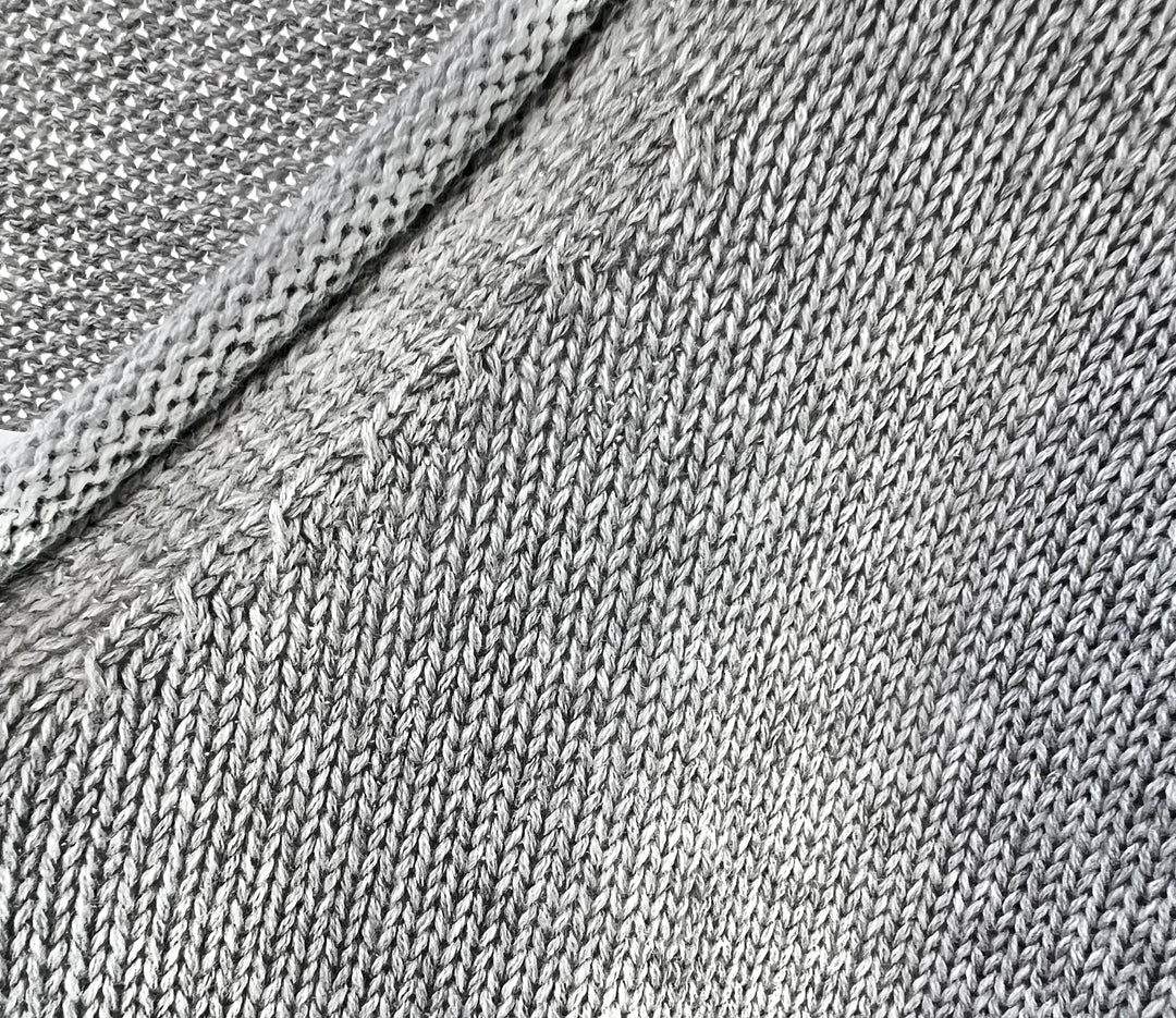 Close-up of gray fabric texture with a diagonal seam