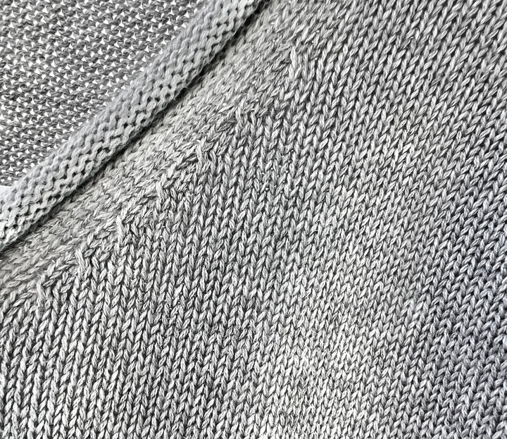 Close-up of gray fabric texture with a diagonal seam