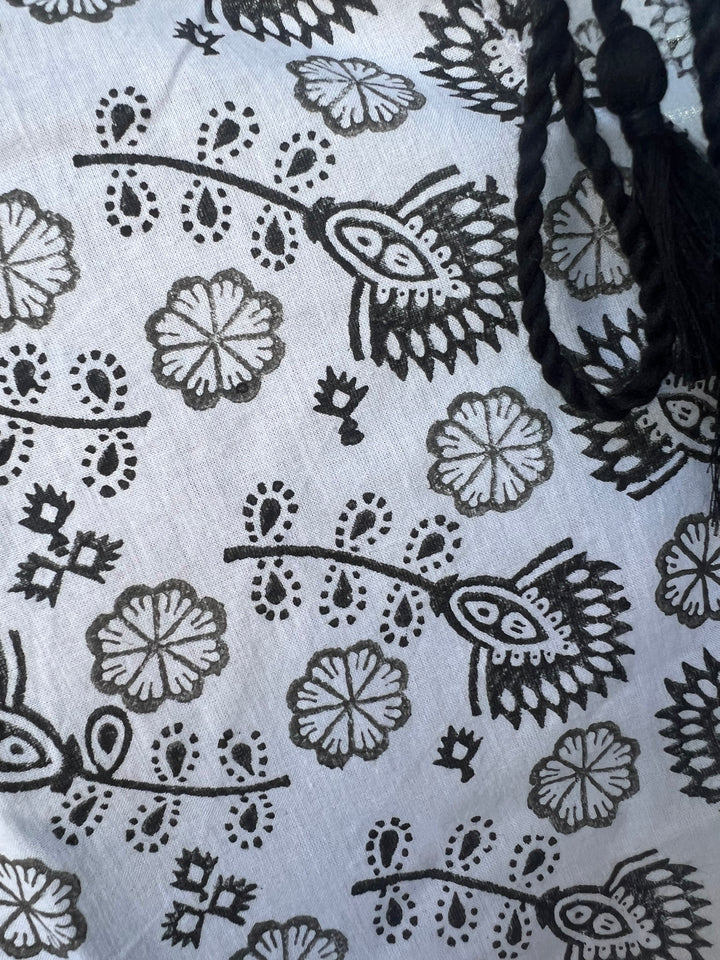 Close-up of a fabric with black floral patterns on a white background