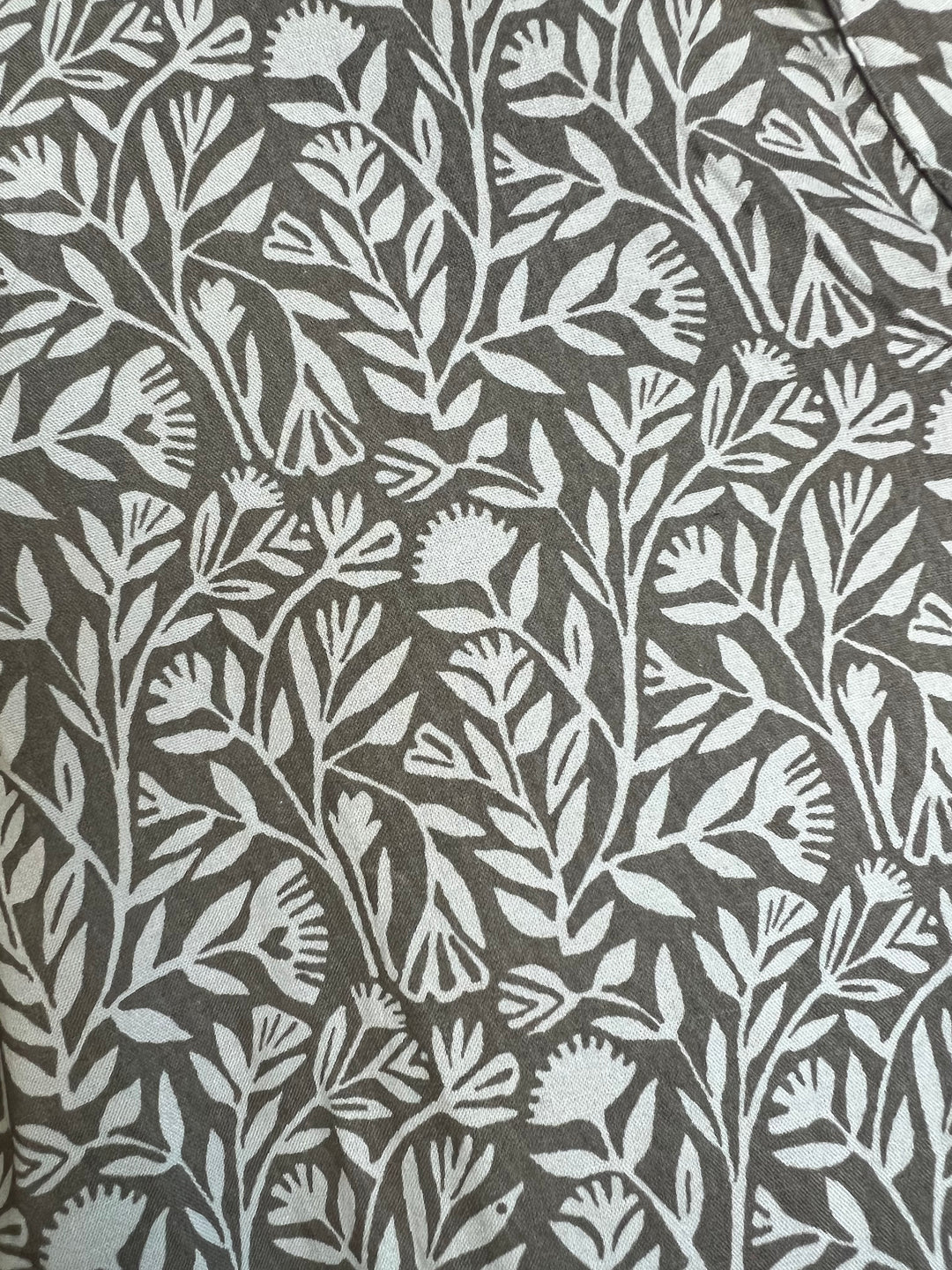 Floral patterned fabric with white leaves on a gray background