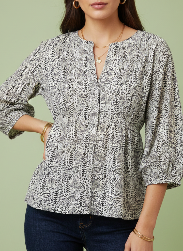 Woman wearing a patterned blouse with a green background