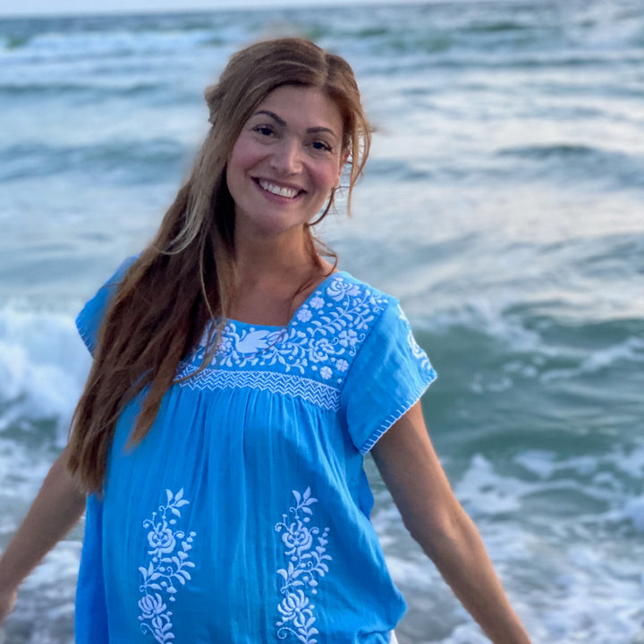 woman in blue and white tunic on the beach