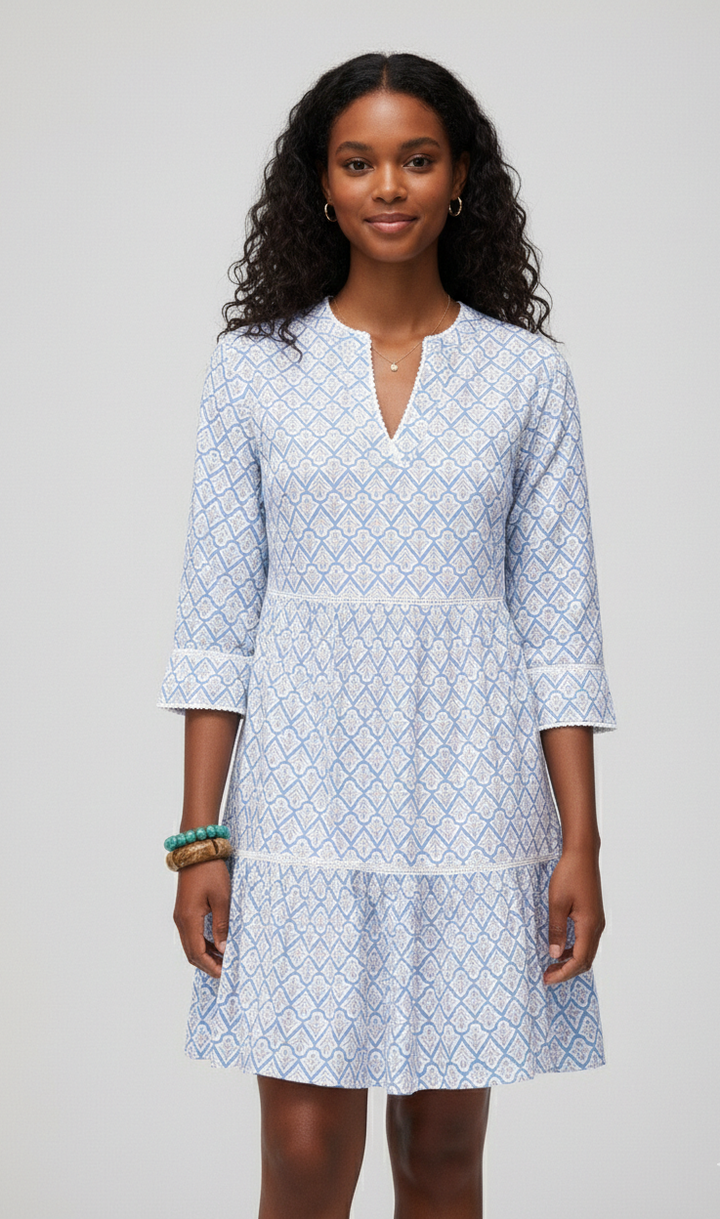 Woman wearing a light blue patterned dress on a gray background